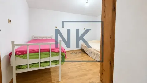 Spavaća soba sa dva kreveta i drvenim podom. - image 7