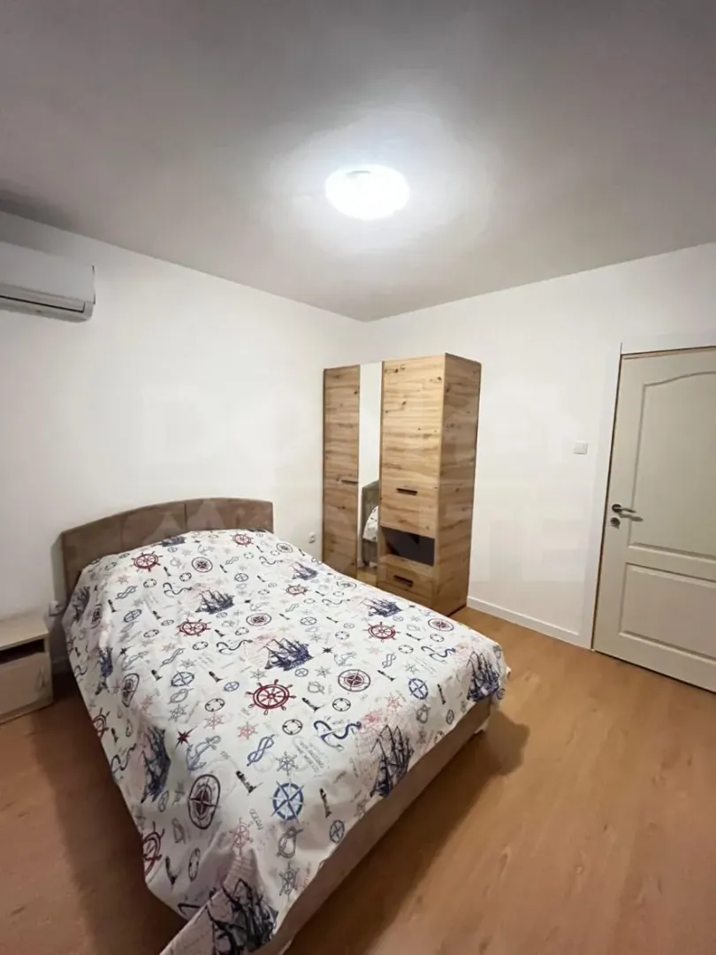 Namještena spavaća soba sa bračnim krevetom, garderoberom i klima uređajem.
