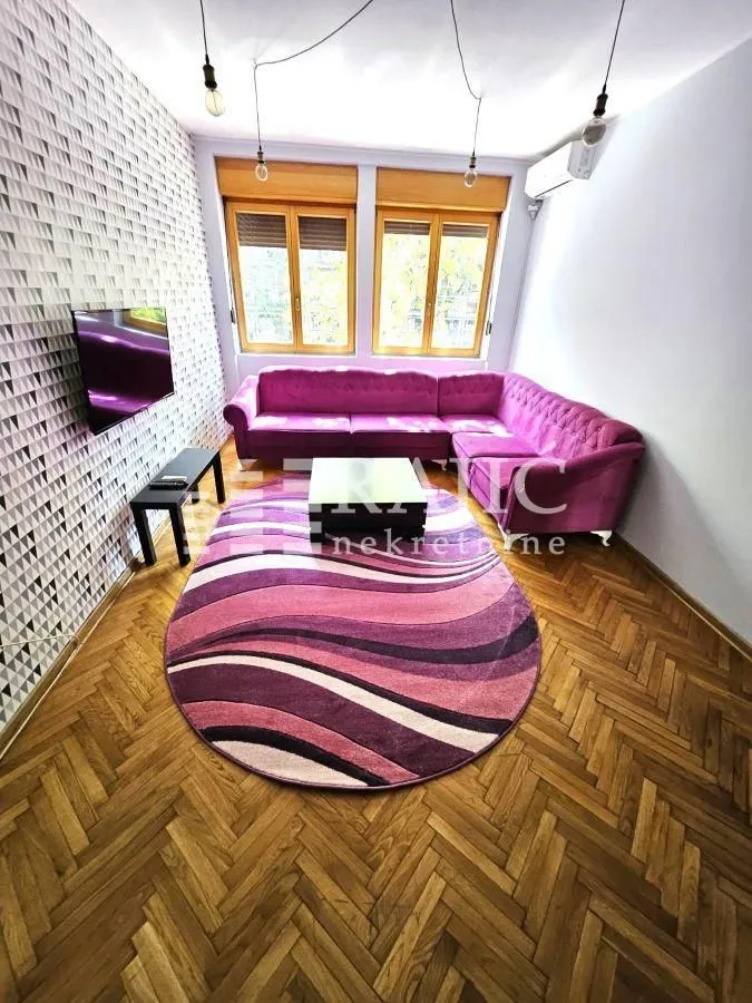 Living room with a sofa and parquet flooring.