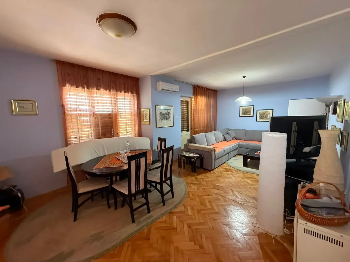 Living room with a dining area and parquet flooring.
