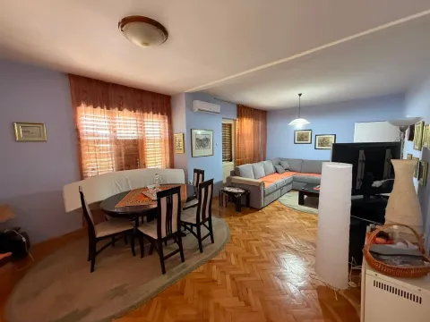 Living room with a dining area and parquet flooring. - image 8