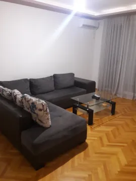 Living room with a dark corner sofa and a glass table. - image 2