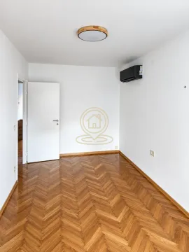Empty room with parquet flooring and an air conditioning unit. - image 3