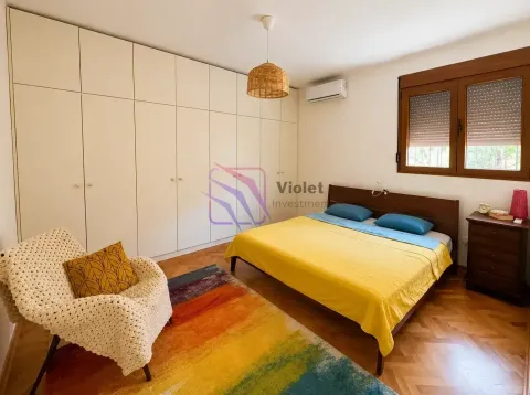 Furnished bedroom with a double bed, large built-in wardrobe, and a colorful rug. - image 11