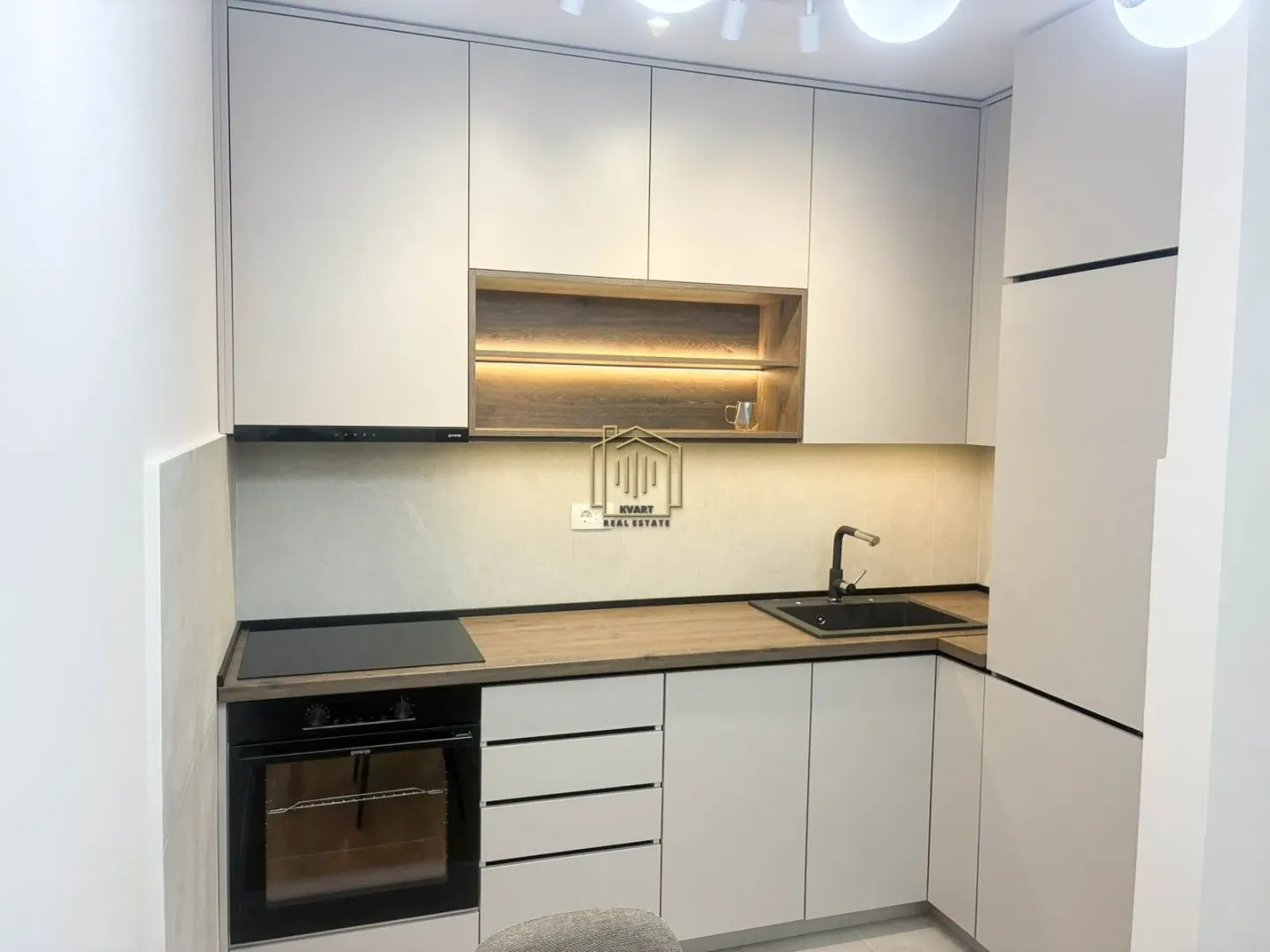 Modern kitchen with built-in appliances and lighting.