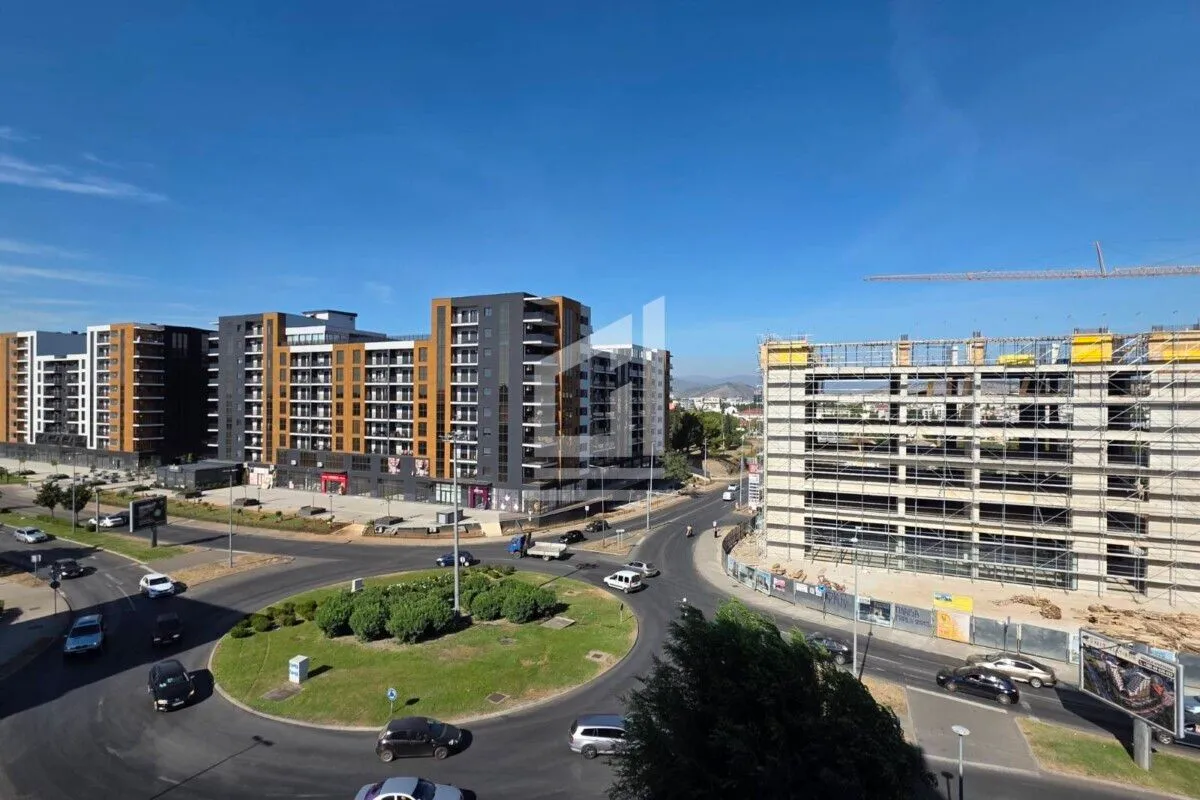 View from the window of surrounding buildings and a road.