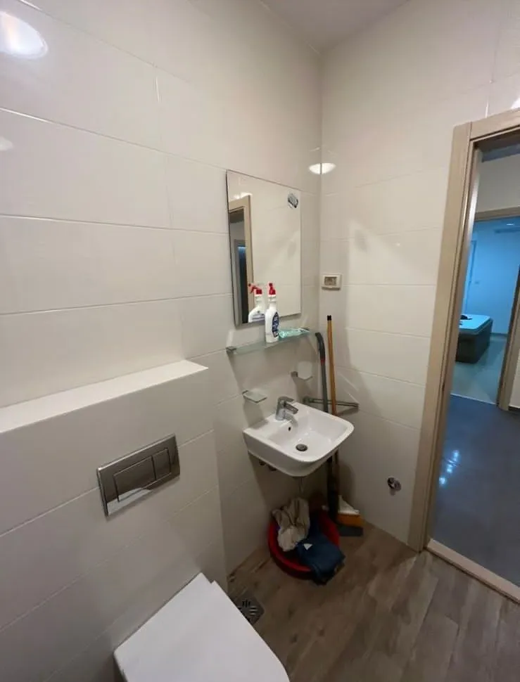 Malo kupatilo sa lavaboom, ogledalom i toaletom.