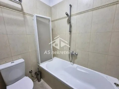 Small tiled bathroom with a bathtub and a toilet. - image 15