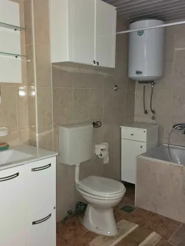 Bathroom equipped with sanitary ware, a washbasin, a bathtub, and a water heater. - image 11