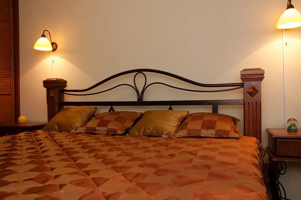 A cozy double bed with decorative pillows and bedside lamps in a bedroom.
