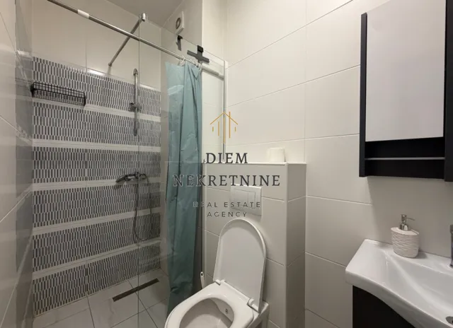 Moderno opremljeno kupatilo sa tuš kabinom.