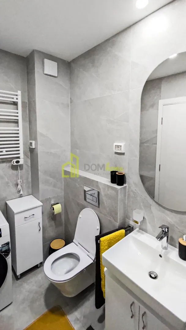 Moderno opremljeno kupatilo sa tušem, umivaonikom i WC šoljom.