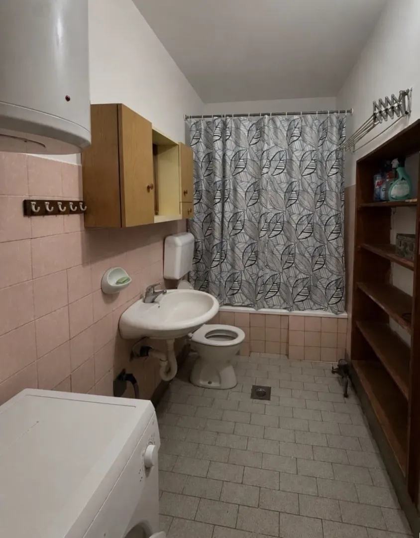 Small bathroom with bathtub, washbasin, and toilet.