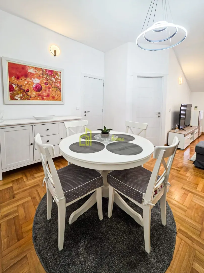 Dining area with a round table and white chairs as part of the living room.