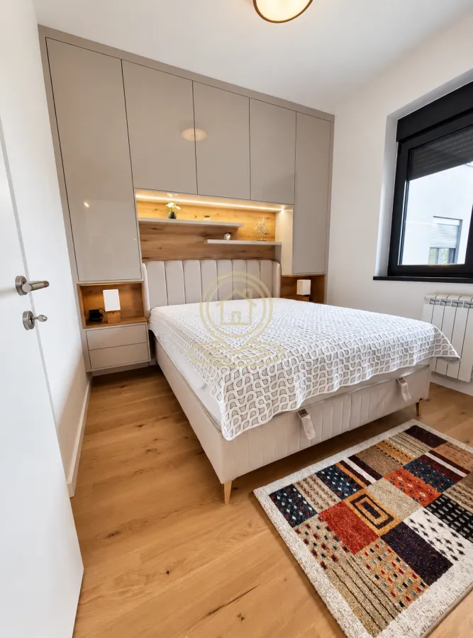 Modern bedroom featuring a double bed, built-in wardrobe, and wooden flooring.