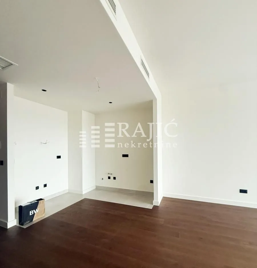 Empty room with hardwood floors and white walls.