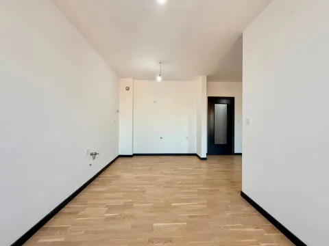 Prazna prostorija sa drvenim podom i bijelim zidovima. - image 6