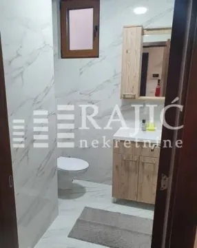 Modern bathroom with a sink, cabinet, mirror, and toilet bowl. - image 12