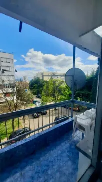 Smaller balcony with a view of surrounding buildings and greenery. - image 10