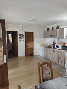 Kuhinja sa drvenim elementima i trpezarijskim stolom. - image 10