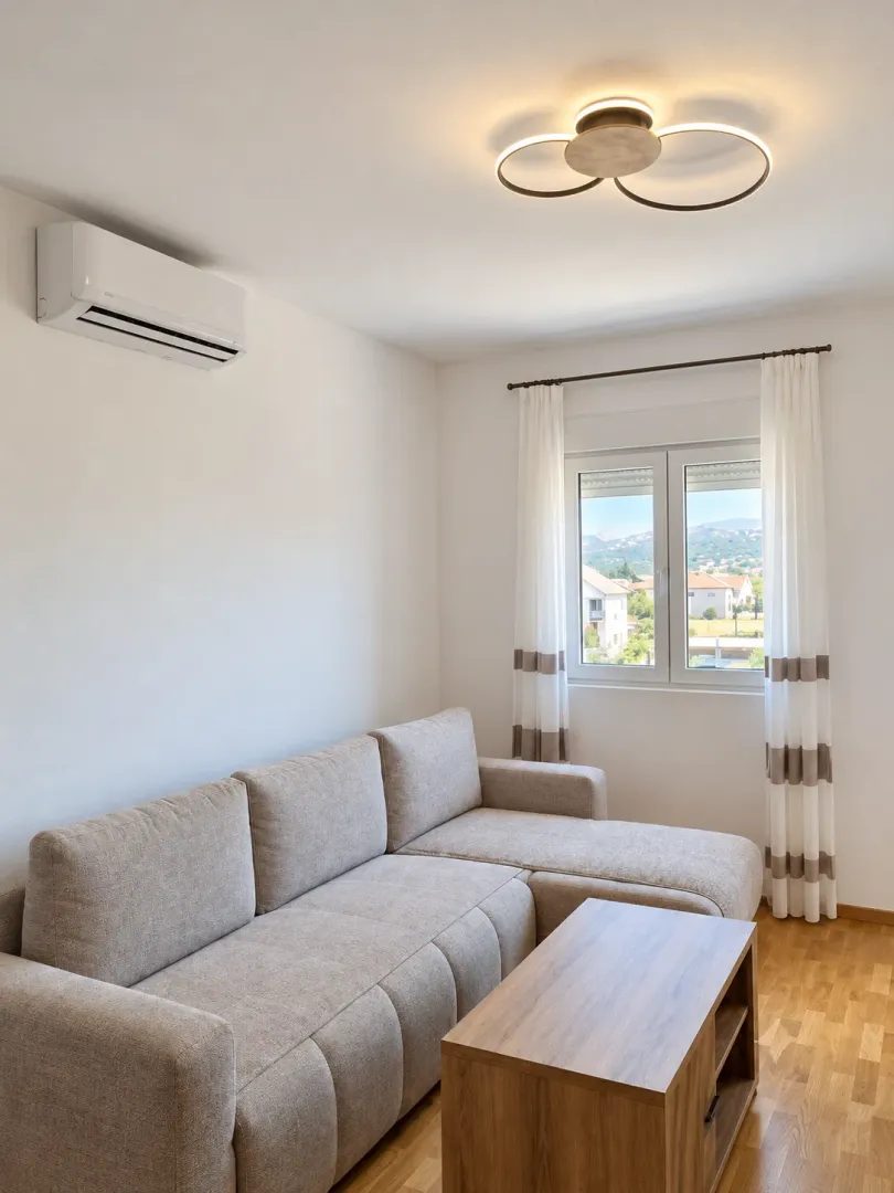 Bright living room with a sectional sofa, wooden coffee table, and air conditioning.