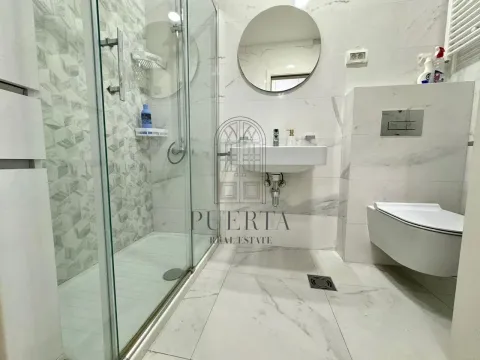 Modernly equipped bathroom with a shower cabin and white marble tiles. - image 11