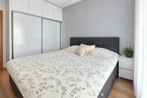 Uređena spavaća soba sa bračnim krevetom, ugradnim plakarom i bijelim noćnim stočićem. - image 12