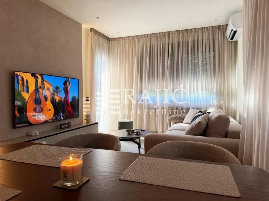 Modern and bright living room with a sofa and television.