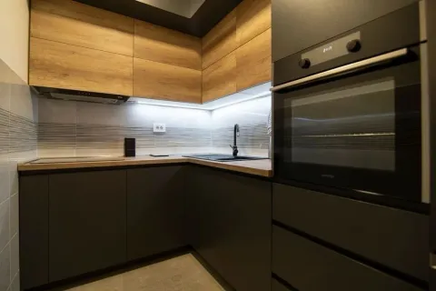 Modern kitchen with dark cabinetry and wooden details. - image 5