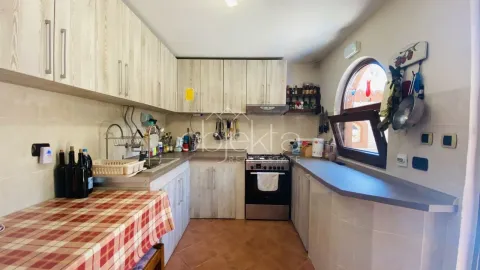 Kitchen equipped with wooden cabinets, a stove, and a countertop with a window. - image 5