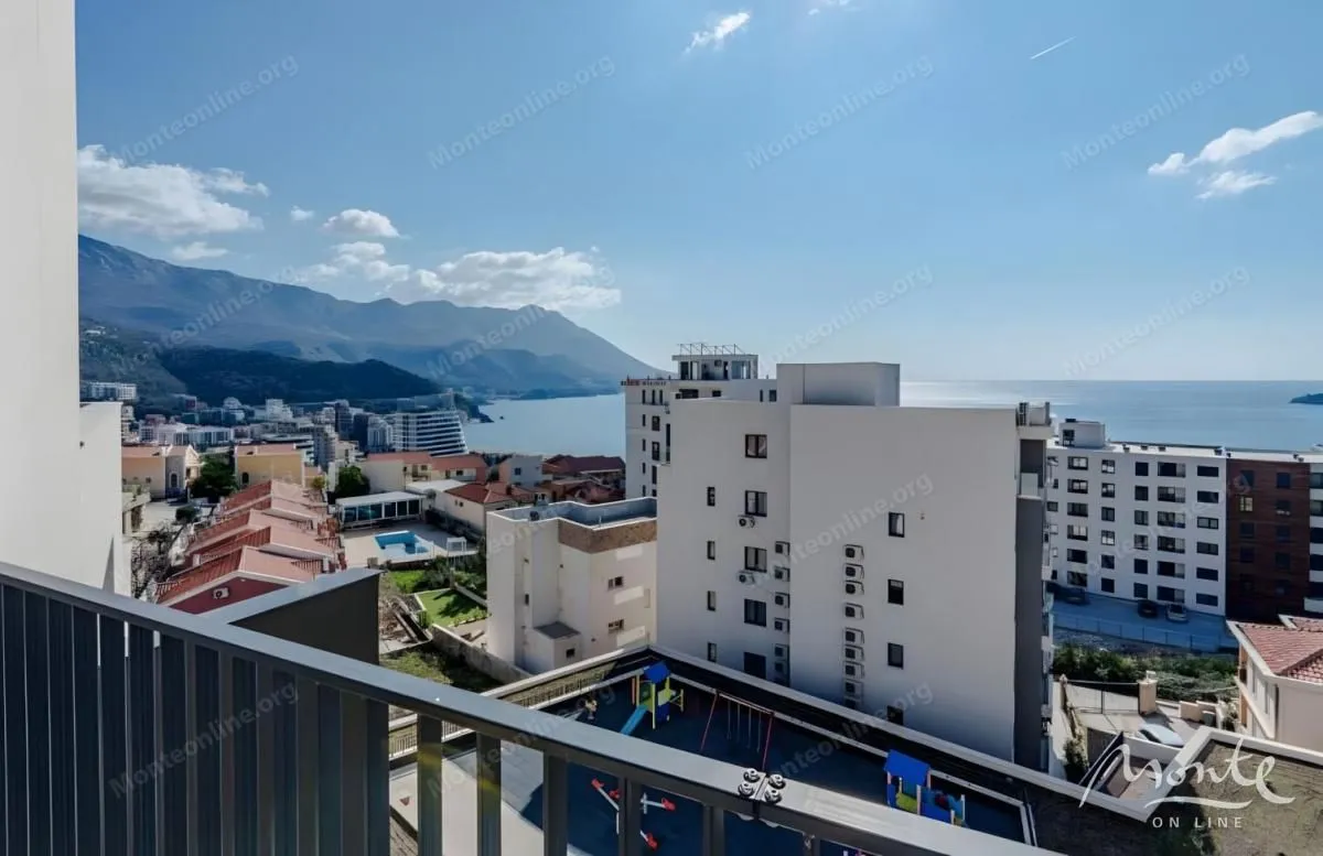 Pogled na more i okolne zgrade sa balkona.