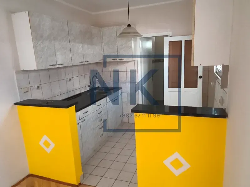 Smaller kitchen with light cabinets and a yellow counter.