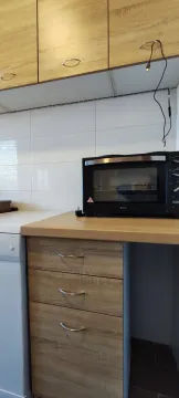 Part of a kitchen with wooden cabinets and a small oven. - image 5