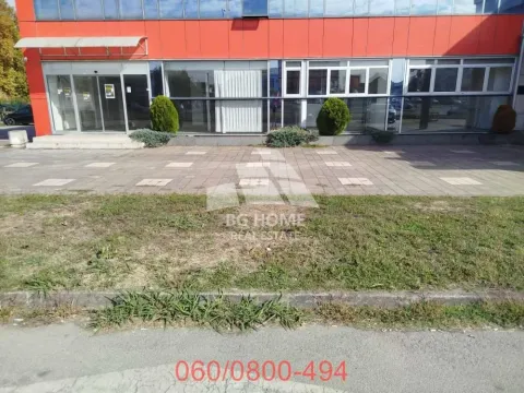 View of the exterior of a commercial building with an entrance and sidewalk. - image 9