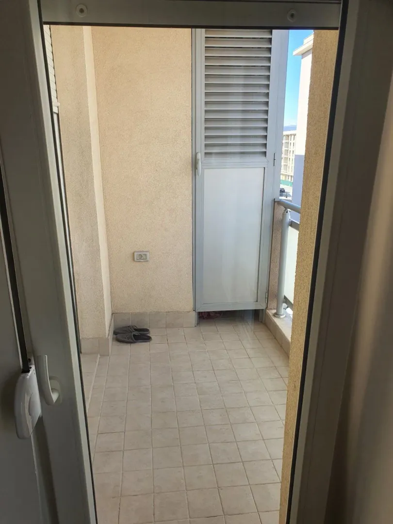 View of a small tiled balcony with balcony doors.