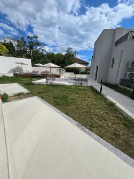 Dvorište zgrade sa bazenom, ležaljkama i suncobranima. - image 11