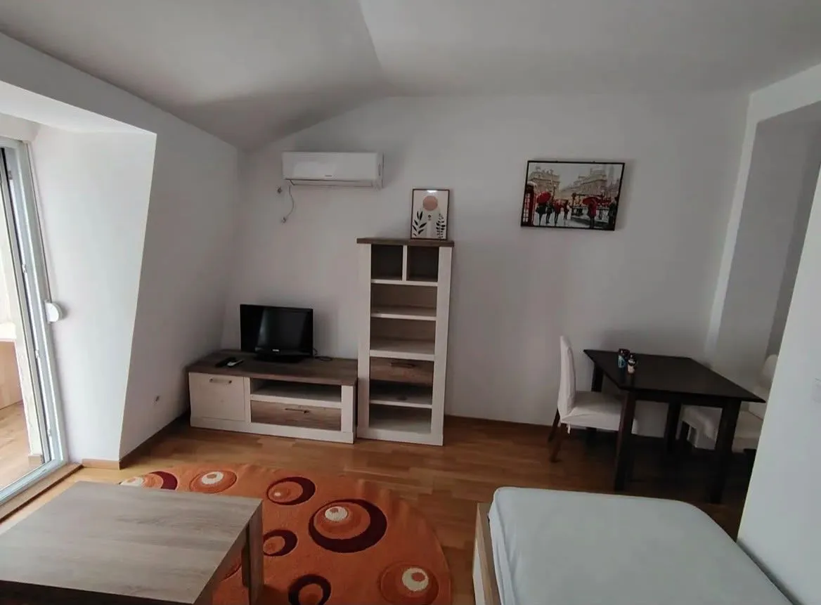 Living room with furniture, TV unit, and dining table.