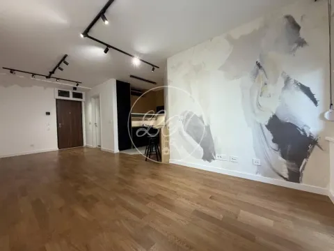 Living room with wooden flooring and a decorative accent wall. - image 5