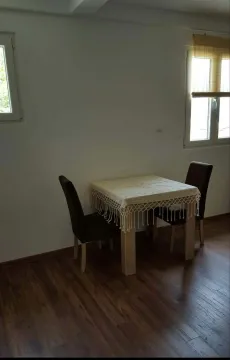 Trpezarijski sto sa dvije stolice u sobi sa drvenim podom. - image 5