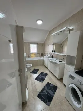 Prostrano kupatilo opremljeno sanitarijama, kadom, umivaonikom i veš mašinom. - image 16