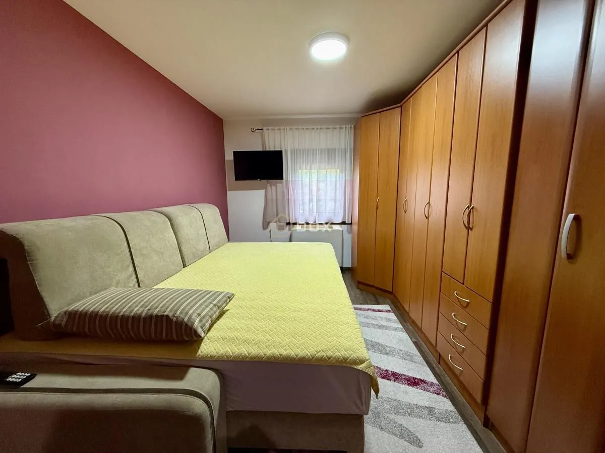 Spavaća soba sa krevetom i velikim drvenim garderoberom.