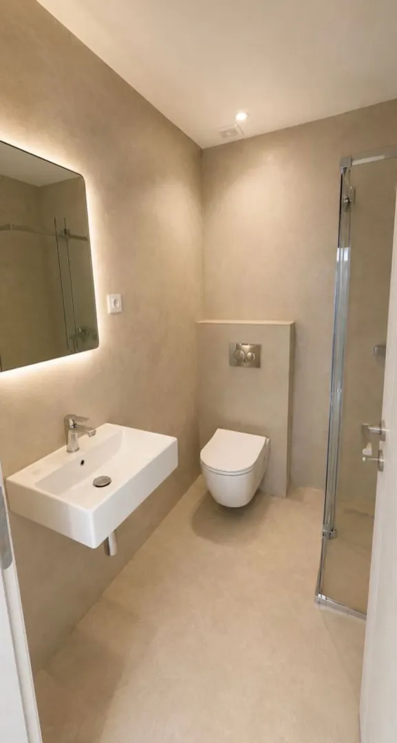 Moderne opremljeno kupatilo sa umivaonikom, wc šoljom i tuš kabinom.