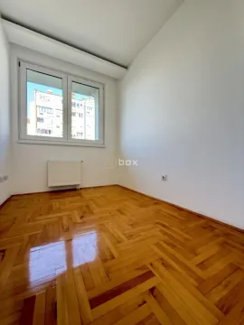 Empty room with parquet flooring and a window overlooking the neighboring building. - image 7