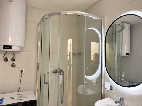 Bathroom with a shower cabin, washbasin, and backlit mirror. - image 7