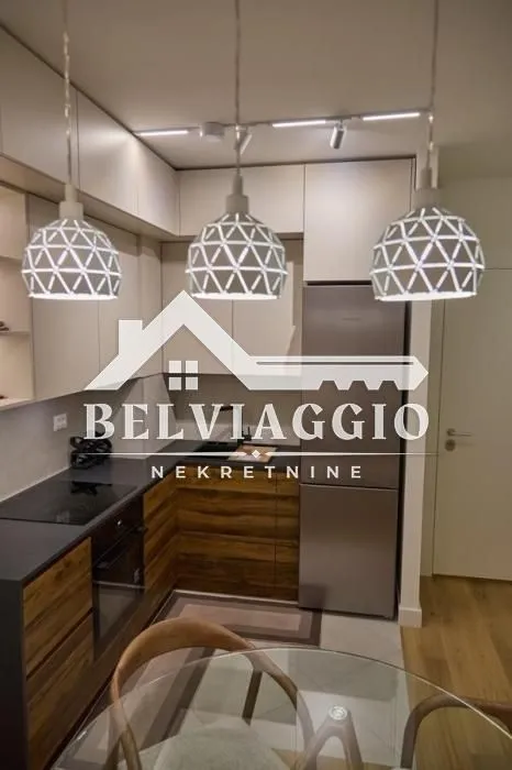 Modern kitchen with wooden lower cabinets, white upper cabinets, and a dining table in the foreground.