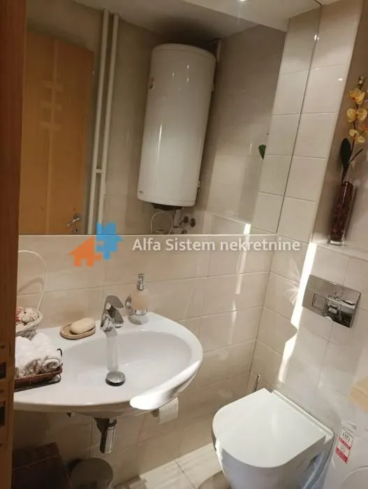 Manje kupatilo sa umivaonikom, WC šoljom i bojlerom.