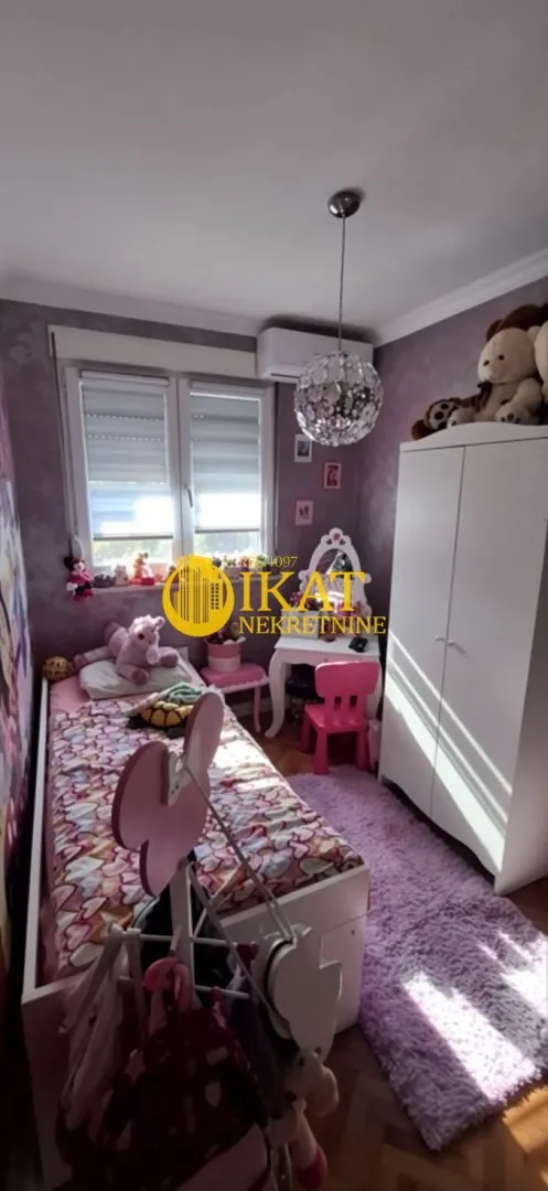 Dečja spavaća soba sa krevetom, garderoberom i prozorom.