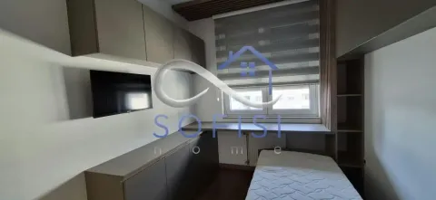 Manja spavaća soba sa krevetom, ugradnim ormarima i TV-om na zidu. - image 14
