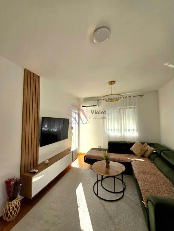 Living room with a sectional sofa, TV, and coffee table.