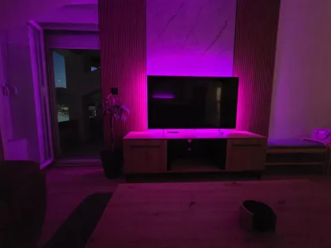 Living room with a television and ambient lighting. - image 23